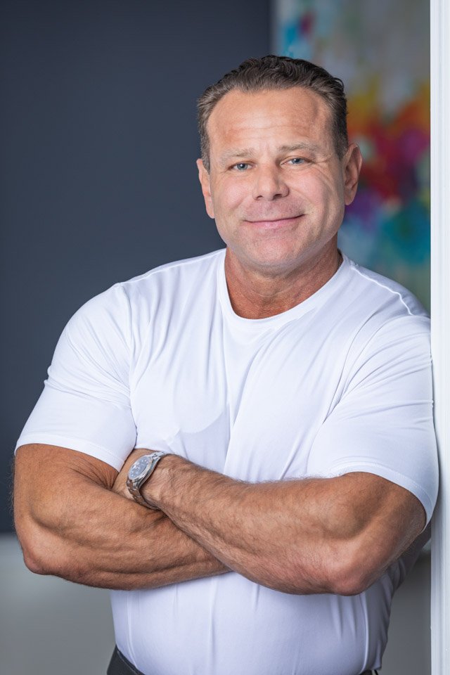 brand-photographer-metro-detroit-michigan Branding photo of a Metro Detroit podcast influencer, photographed in a brand portrait. This casual, leaning against the wall image displays brand photo attributes