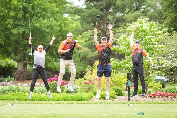 golf-event-corporate-outing-photographer-1 Four golfers jumping at the Kovan charity fundraiser in Birmingham, Michigan.