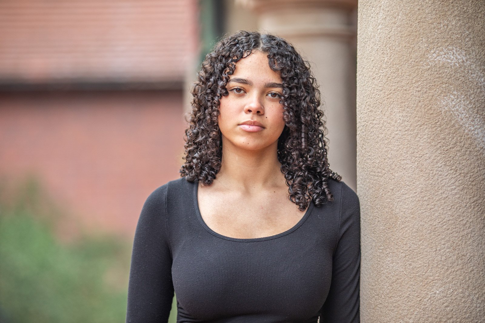 senior-portrait-cranbrook-school, bloomfield-hills-photographer High shool senior portrait taken of a girl in a black top, looking into the camera, with a blurred background