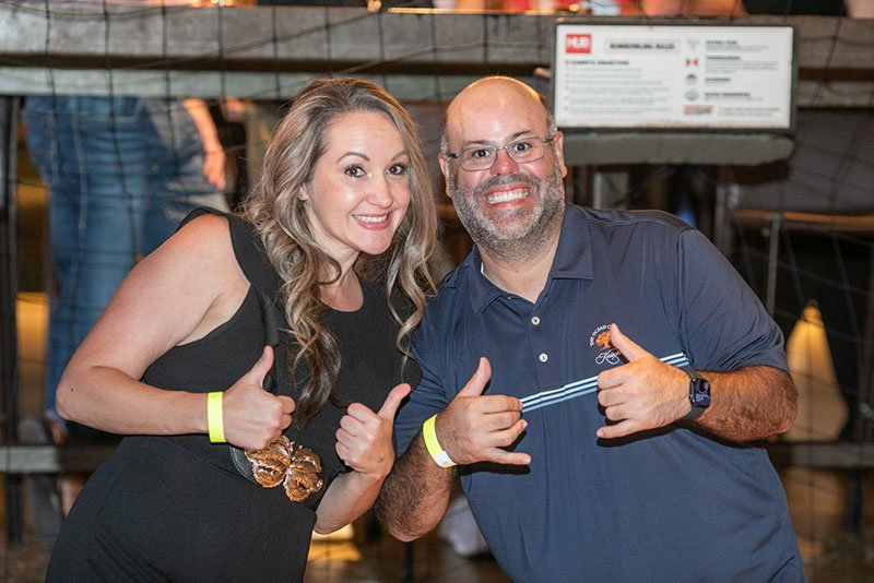 Team Members Giving Thumbs Up at HUB Stadium Two corporate event attendees smiling and giving thumbs up at The HUB Stadium in Auburn Hills