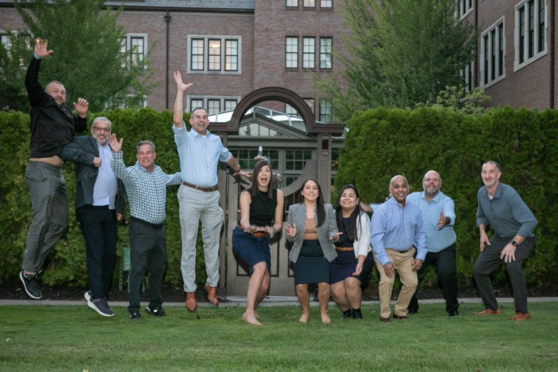 Ally team jumping outside Royal Park Hotel during corporate retreat