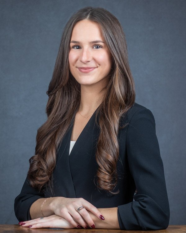 Professional corporate headshot of a business professional on a neutral background