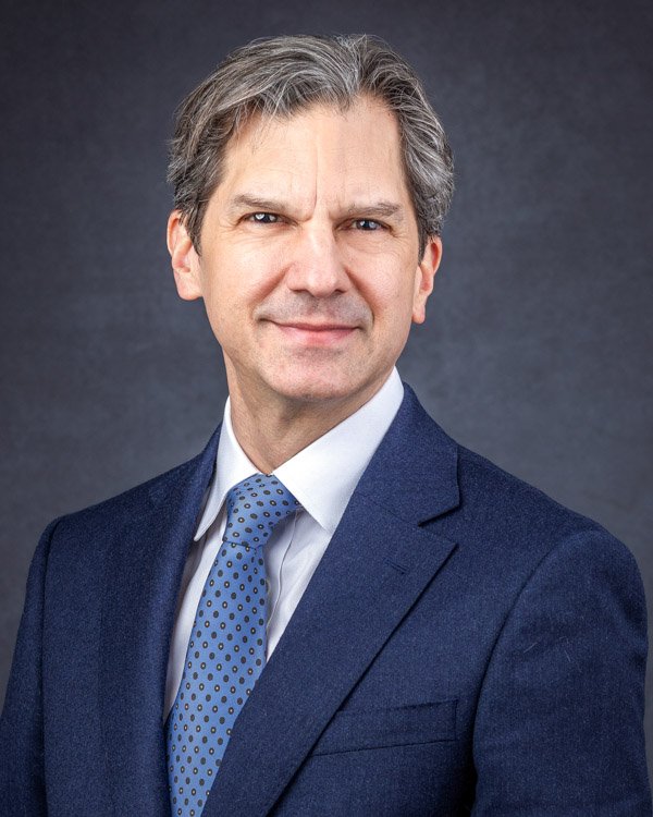 Executive-level corporate headshot with consistent studio lighting