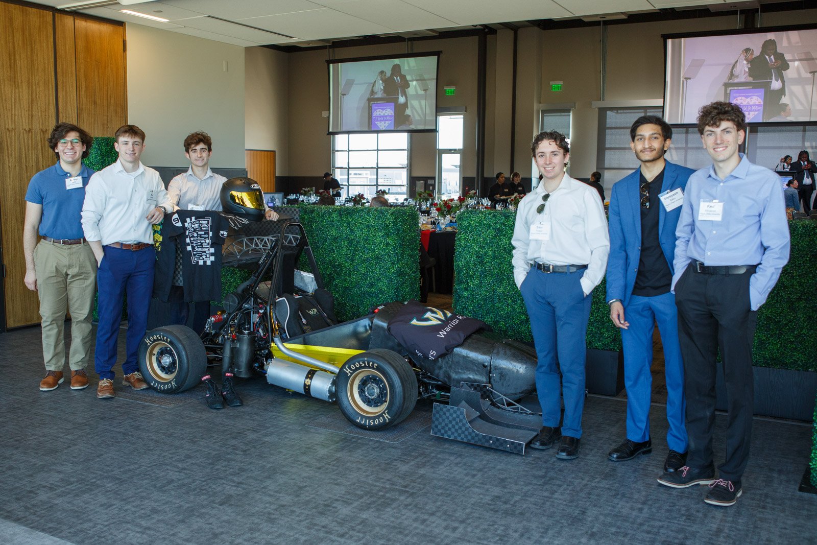 Attendees networking around automotive display at corporate event in Detroit Michigan