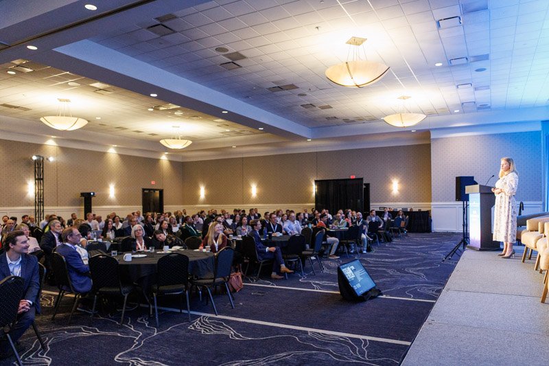 Keynote speaker presenting to a large corporate conference audience