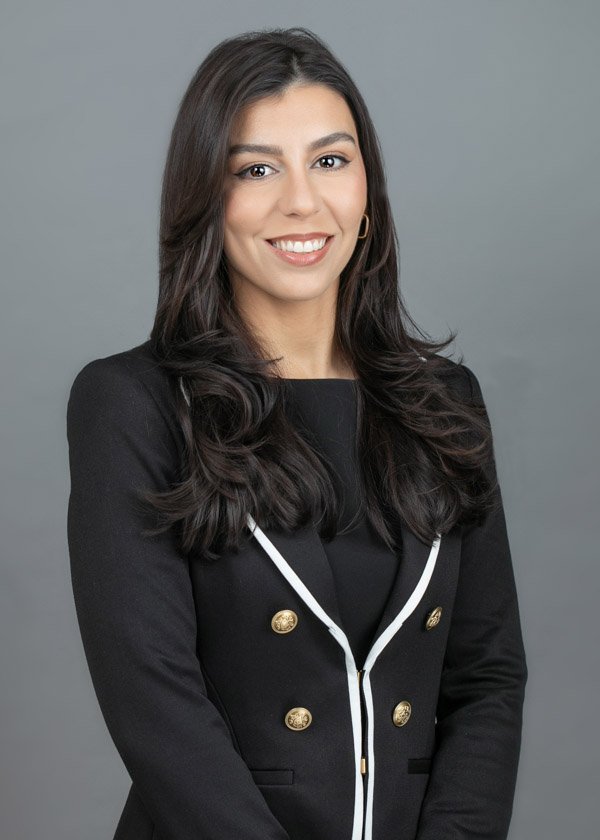 Professional ERAS headshot of a medical residency applicant wearing a black blazer on a neutral gray background.