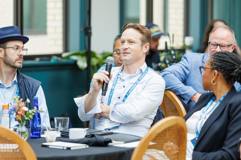 Attendee speaking during a corporate roundtable discussion at Book Tower in Detroit
