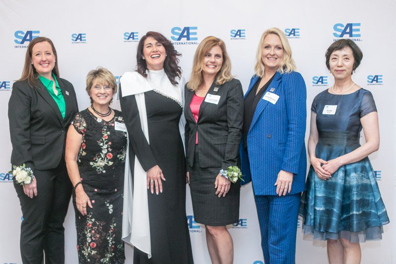 Group photographed at an SAE awards event with branded step and repeat backdrop Detroit