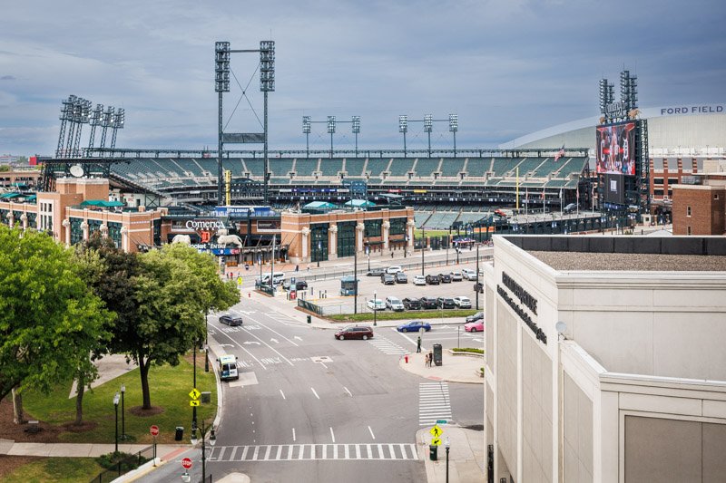 Elevated view of Comerica Park and Ford Field in downtown Detroit, Michigan, showing the stadiums and surrounding city streets.