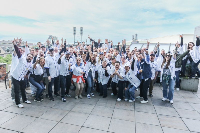 Fords Garage corporate team celebrating at a rooftop event overlooking Comerica Park in downtown Detroit.