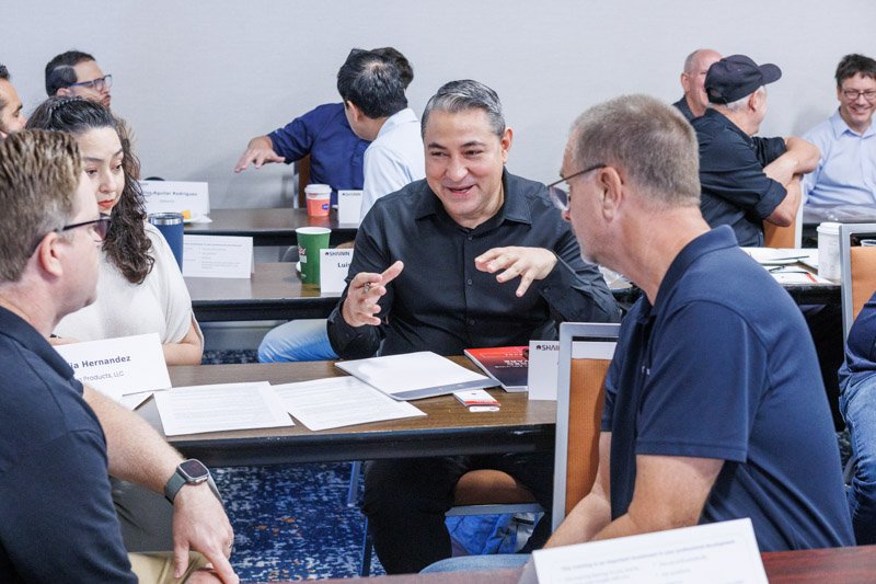 Participants collaborating during a small-group discussion at a Shainin corporate training workshop.